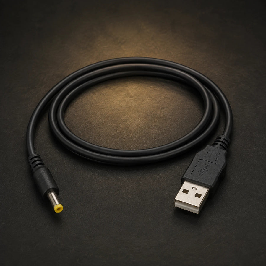 USB-A to yellow-tipped PSP charging cable on a charcoal and gold studio background